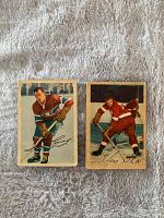 Front view of two 1953-54 Parkhurst hockey cards showing players Floyd 'Busher' Curry and Glen Skov in team uniforms with hockey sticks.
