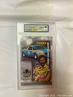 Front of graded display showing colored Dale Earnhardt card and quarter coin with WCG grading label
