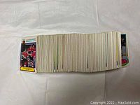 Stack of front-facing hockey cards fanned out showing player images, mostly in red team jerseys with some blue and yellow visible.