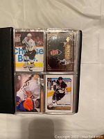 Photo showing four Sidney Crosby hockey cards in a binder sleeve, with different designs including action shots and a phenom card.