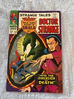 Front cover of Strange Tales #152 featuring Doctor Strange casting a spell with a green mystical hand and a woman in red and black.