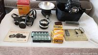 Overview of all cameras, flash, film, manuals and accessories on table