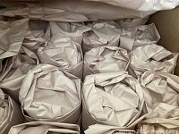 Packed stemmed drinking glasses wrapped in brown paper inside a box