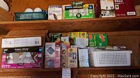 Various boxes of new light bulbs and loose bulbs on wooden shelves including Philips and Conserv-Energy brands.