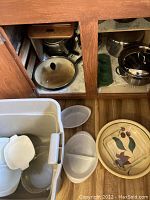 Photo showing various pots, pans, mixing and serving bowls including vintage baking dishes with floral design and plastic segmented bowl.