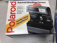 Front and side view of the box for Polaroid OneStep Camera showing branding and product image.