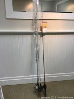 Four Zebco spinning rods and reels standing upright with a torn label showing the Zebco branding attached to one rod.