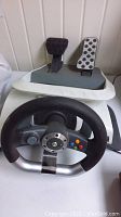 Racing wheel front view with pedals showing button layout and grip design