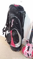Side view of golf bag showing brand logo and zippered pockets