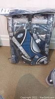 Full view of Cooper goalie pads, blocker, and catcher packed in plastic storage bag showing brand and colors.