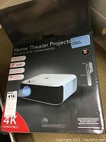 Box front showing home theater projector image and features including 4K compatibility, HDMI, and 20,000-hour lamp life