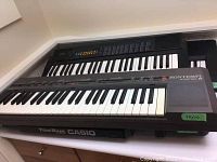Four electronic keyboards stacked; Bontempi Minstrel and Casio Tone Bank visible with key counts and labels.