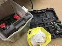 Clear view of two cordless drills and a plastic bin containing tools.