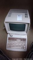 Full view of beige Informer vintage computer terminal with attached keyboard showing keys, screen, ventilation slots, and cord.