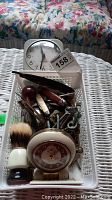 Photo showing the entire lot including alarm clocks, razor, shaving brush, pocket cutters, keys.