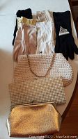 Group of six pairs of vintage ladies gloves in assorted colors size 7.5 with three vintage clutch purses including woven white, pearl-beaded and metallic gold style.