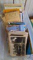 Box full of vintage postcards and greeting cards bundled and stacked
