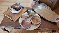 Overview of all wooden serving items including trays, bowls, and lazy Susan displayed on a wooden table.