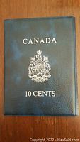 Blue coin folder cover with silver crest and text CANADA 10 CENTS on front