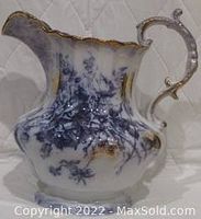 Close side view of the blue and white floral Harley pattern pitcher with gold trim and ornate handle, showing molded leaf detail.