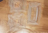 Three vintage Federal Glass bowls with diamond point pattern and ruffled edges laid on floor: two square, one rectangular.