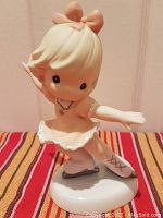 Front view of the porcelain figure skater figurine showing the detail of the face, dress, and pose.