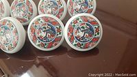 Close-up of ceramic drawer pulls featuring colorful Asian motif design.