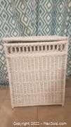 White wicker laundry basket with woven construction, lid closed, showing overall shape and size.