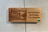 Engraved wooden box lid showing 2004 World Series Red Sox championship banner and text '2004 World Series Busch Stadium Visitors Bench Pen' with holographic sticker.