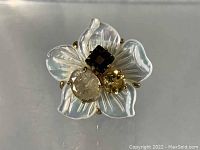 Front view of Bounkit gold plated cocktail ring showing white petals and three stones.