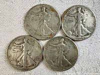 Obverse side of 4 Walking Liberty Half Dollars showing dates 1939, 1939, 1937, and 1938 with visible wear and age-related tarnishing.