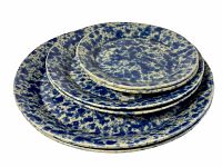 Stack of six Bennington pottery plates showing small, medium, and large sizes with blue spatter pattern.