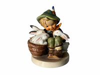 Front view of the Playmates #58 Hummel figurine showing the boy sitting with two rabbits in a basket.