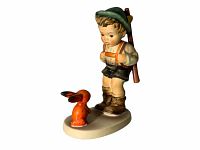 Porcelain figurine of a young boy hunter with an orange rabbit, standing on an oval base against a white background.