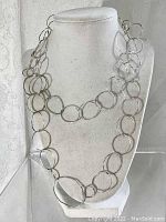 Sterling silver necklace displayed on a jewelry bust, showing the full length and the size of circular links.