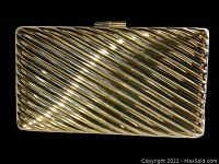 Front view of vintage Italian gold-toned metal clutch with diagonal ribbed design, closed with clasp top.