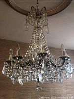 Full view of eight-light chandelier hanging from ceiling