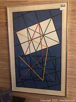 Full view of the framed artwork leaning against a wall