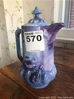 Front and side view of vintage Limoges coffee pot showing its blue floral pattern, sculpted handle, and ornate lid.