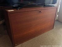 Front view of rectangular wood cabinet with drop-down front panel