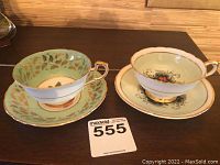 Side view of two Paragon tea cups and saucers on wood table
