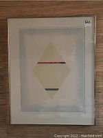 Framed art print featuring abstract diamond shape and colored stripes