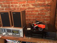 Wide view of entire stereo setup showing cassette deck, CD changer, speakers, cables and remote.