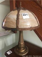 Frontal view of lamp showing slag glass shade and metal base