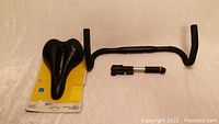 Photo showing Selle Royal supportive bike seat, black drop handlebars, and portable bike tire pump on a white background.