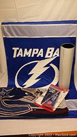 Blue Tampa Bay Lightning fabric banner laid out with rolled poster and unopened MLB mini pennants