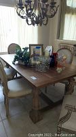 Full view of rectangular ash wood dining table with decorative items on top