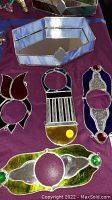 Stained glass decor items arranged on a purple cloth, showing the hexagonal mirrored tray and four stained glass hanging or ornamental pieces with color and design details.