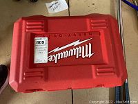 Closed red Milwaukee heavy-duty carrying case with white logo on top.