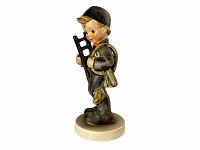 Side view of Hummel Chimney Sweep #12 figurine showing the boy holding a ladder and sack, mounted on circular base.